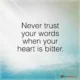 An inspirational quote reading 'Never trust your words when your heart is bitter.' in clean black sans-serif text over a soft background illuminated by a gentle beam of light on a teal wooden floor surface. Never Trust Your Words When Your Heart Is Bitter Quote A wise life quote warning against speaking in anger or resentment