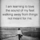 A grayscale inspirational quote card reading 'I am learning to love the sound of my feet walking away from things not meant for me.' featuring a lone person walking down an empty country road. Walking Away From Things Not Meant For Me Quote Card